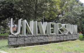 Letras de la entrada de Universum rodeadas de árboles, en una fotografía de archivo.