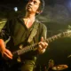Akira Yamaoka toca la guitarra durante un concierto