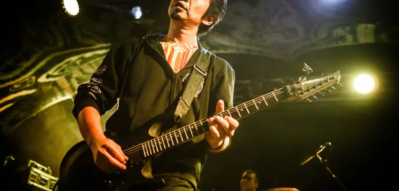 Akira Yamaoka toca la guitarra durante un concierto