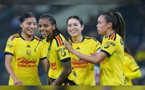 Cuatro jugadoras de América Femenil celebran juntas durante un partido