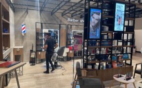 Interior de una barbería con sillas, espejos y estaciones de trabajo