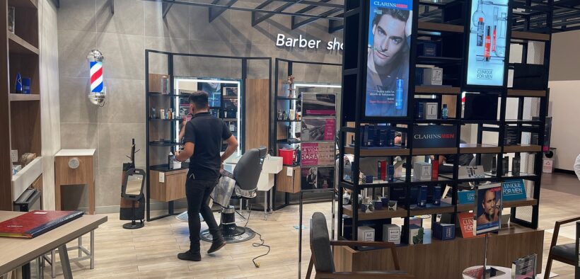 Interior de una barbería con sillas, espejos y estaciones de trabajo