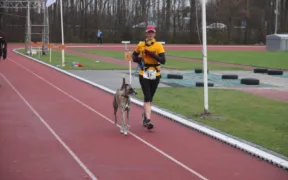 Mujer corre una carrera acompañada por un perro