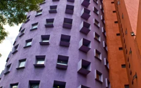 Edificios de fachadas morada y roja del Centro Nacional de las Artes en Coyoacán.