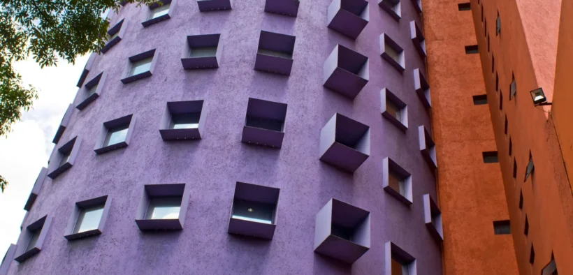 Edificios de fachadas morada y roja del Centro Nacional de las Artes en Coyoacán.