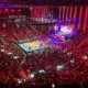Vista general de una arena del CMLL llena de aficionados alrededor del ring iluminado
