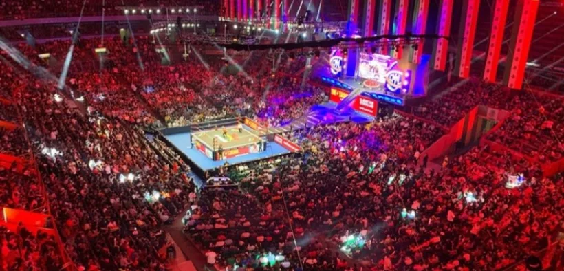 Vista general de una arena del CMLL llena de aficionados alrededor del ring iluminado