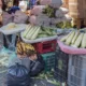 Puesto en la calle con elotes, plátanos y costales sobre cajas de plástico en un mercado de la Ciudad de México