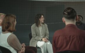 Grupo diverso de personas conversa sentado en círculo; imagen contextual de diálogo comunitario.