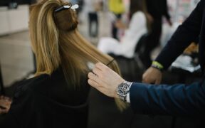Un profesional peina a una modelo durante un evento de moda en abril de 2022