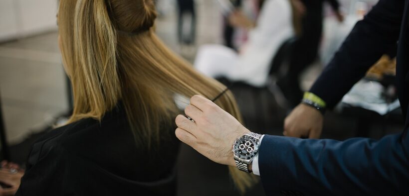 Un profesional peina a una modelo durante un evento de moda en abril de 2022