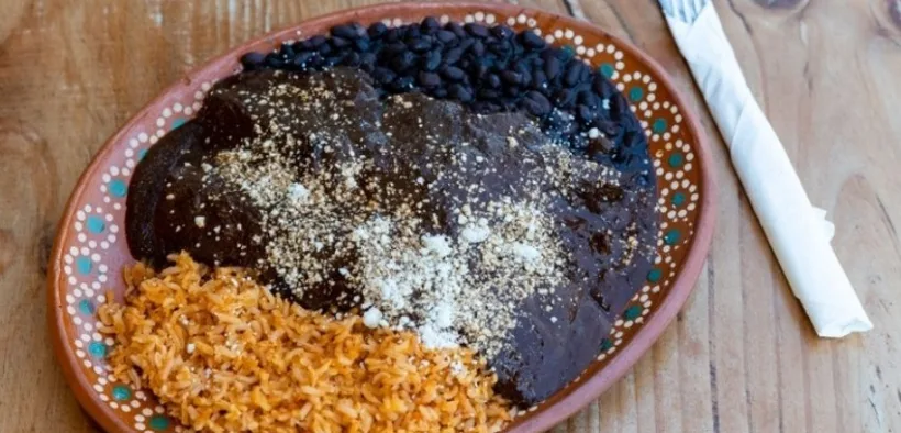 Plato de mole con arroz rojo y frijoles negros