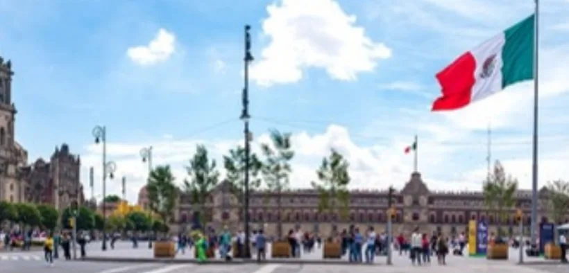 Plancha del Zócalo con el Palacio Nacional y la bandera monumental bajo un cielo despejado