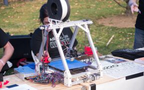 Impresora 3D en funcionamiento durante una feria de cultura maker