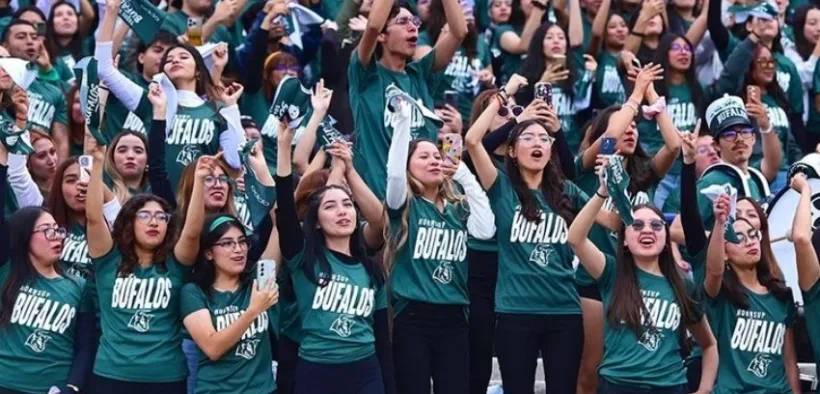 Estudiantes con playeras verdes animan desde las gradas durante la inauguración de los Juegos Universitarios en el Estadio Olímpico Universitario