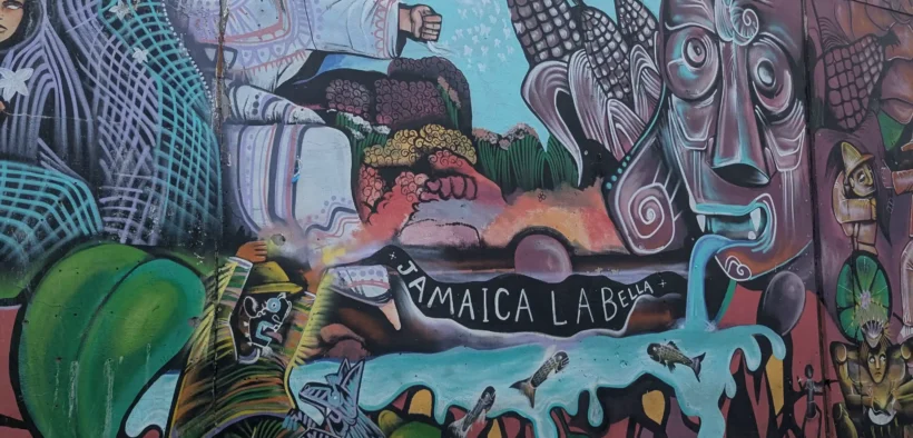 Mural con flores, mazorcas y figuras humanas en un muro del Mercado de Jamaica.