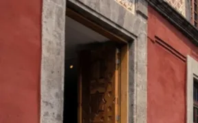 Portón de madera y muros rojos del Museo Archivo de la Fotografía en el Centro Histórico