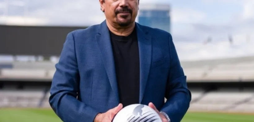 Hugo Sánchez sostiene un balón en la cancha del Estadio Olímpico Universitario