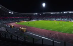 Estadio de futbol iluminado por reflectores durante la noche