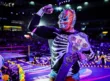 Luchador del CMLL con atuendo de esqueleto y cinturón de campeón en la Arena México decorada por Día de Muertos