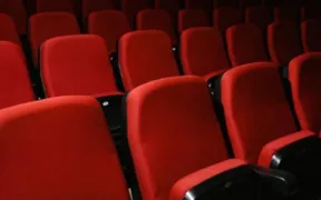 Filas de butacas rojas vacías en una sala de cine