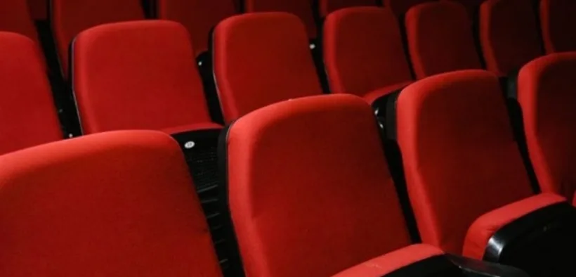 Filas de butacas rojas vacías en una sala de cine