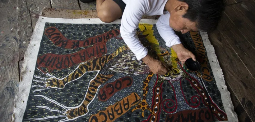 El artista Santiago Yahuarcani trabaja sobre una pintura en su taller