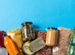 eating, charity and donation concept - close up of different packed food on blue background