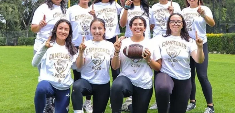 Jugadoras de UNAM Azul posan con playeras de campeonas y un balón de futbol americano